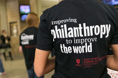 Back of a t-shirt reading "improving philanthropy to improve the world"